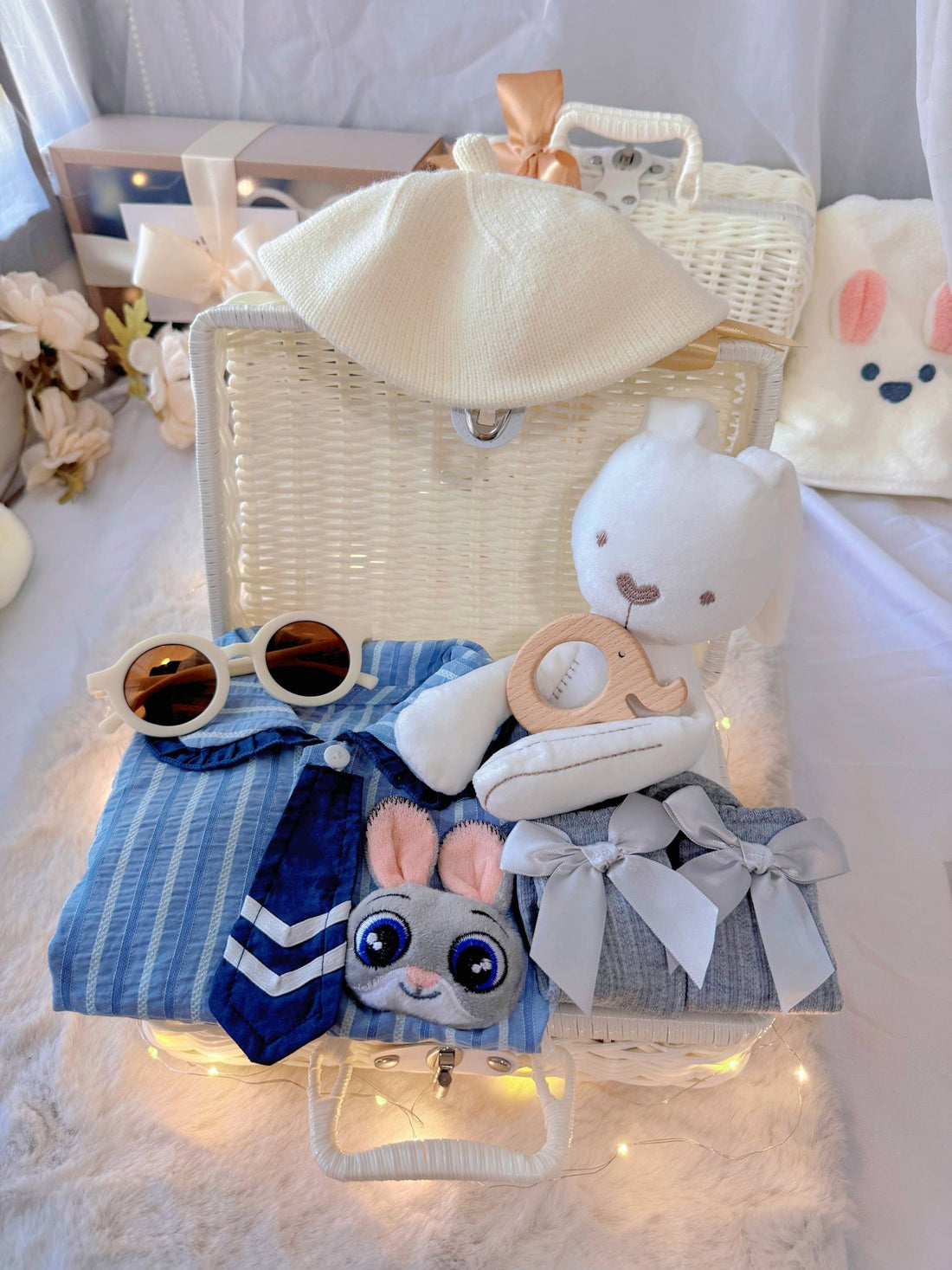 Judy Bunny premium baby gift set in a rattan basket with blue striped romper with tie and bunny badge