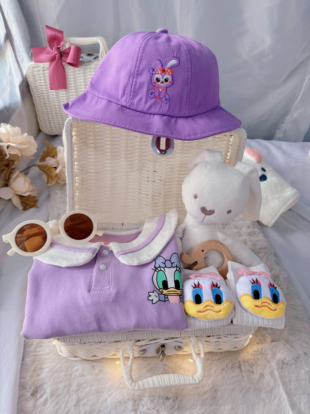 Little Daisy premium baby gift set in a rattan basket with lilac duck-collar romper with bucket hat