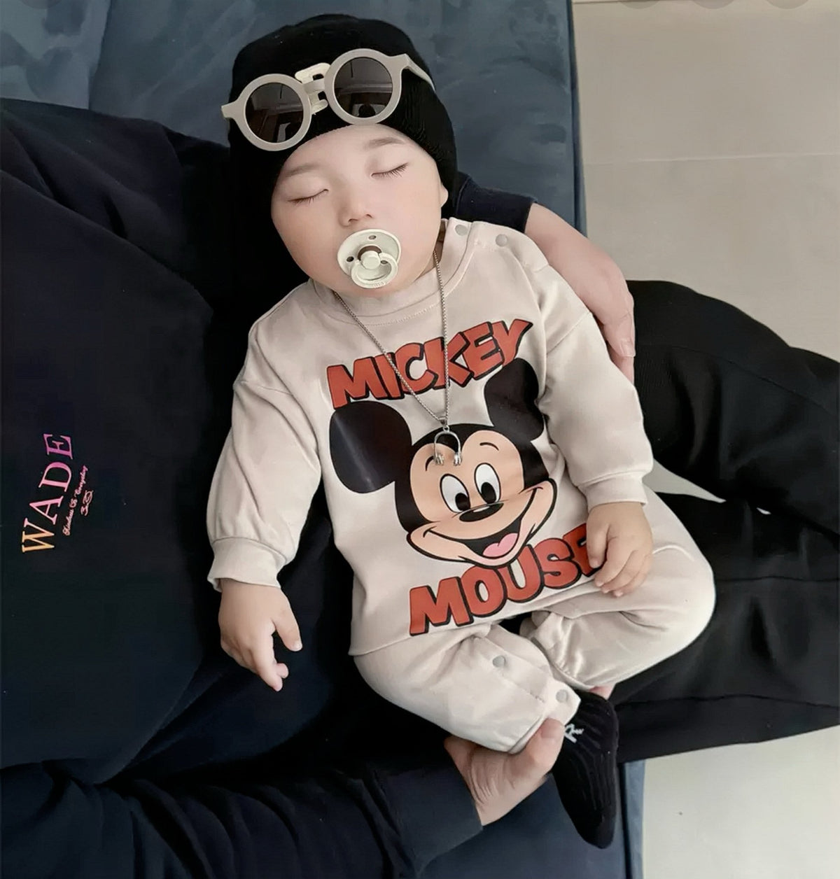 Baby wearing the Mickey Pals mouse-print romper with black beanie