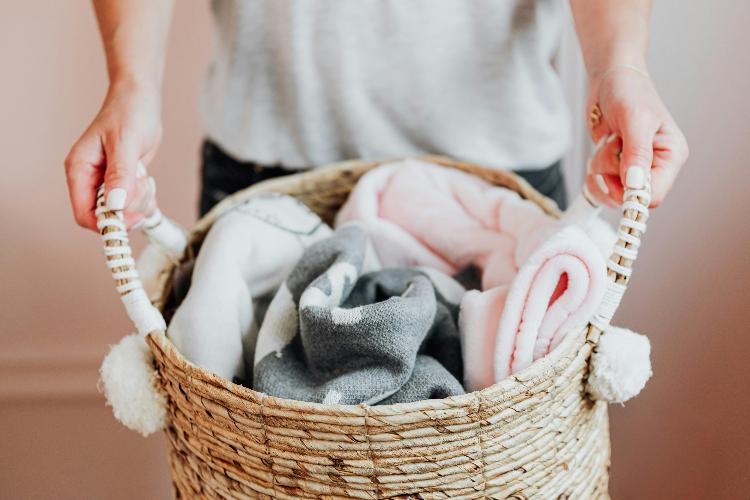 Rattan gift basket filled with soft baby clothes