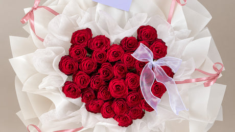 The Deep Love 33 Red Roses Heart Bouquet in white wrapping with pink ribbons