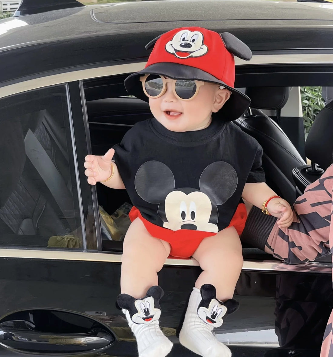 Baby wearing the Baby Mickey red and black mouse-themed romper