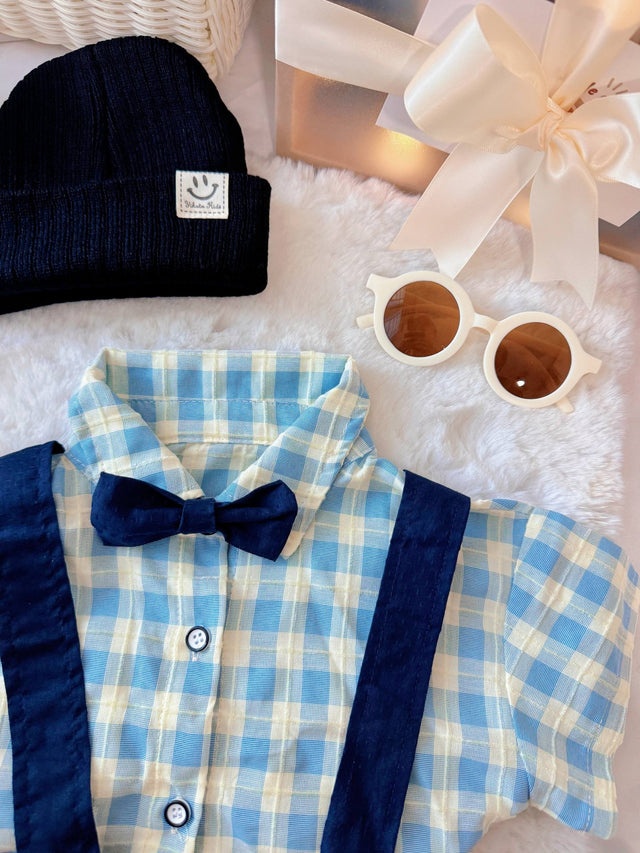Charlie Boy baby outfit flat lay – blue gingham shirt with bow tie and suspender shorts