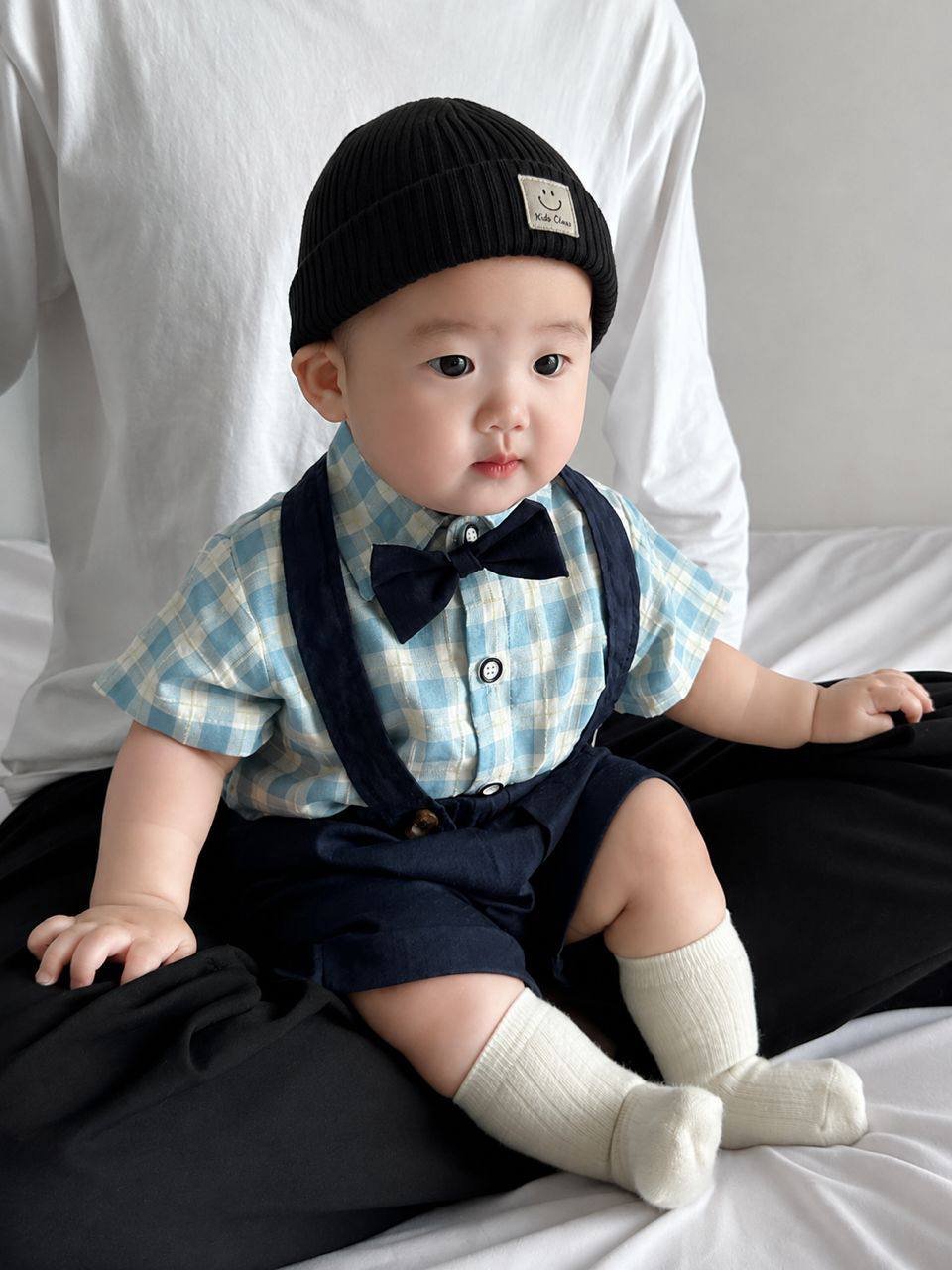 Baby wearing the Charlie Boy blue gingham shirt with bow tie and suspender shorts