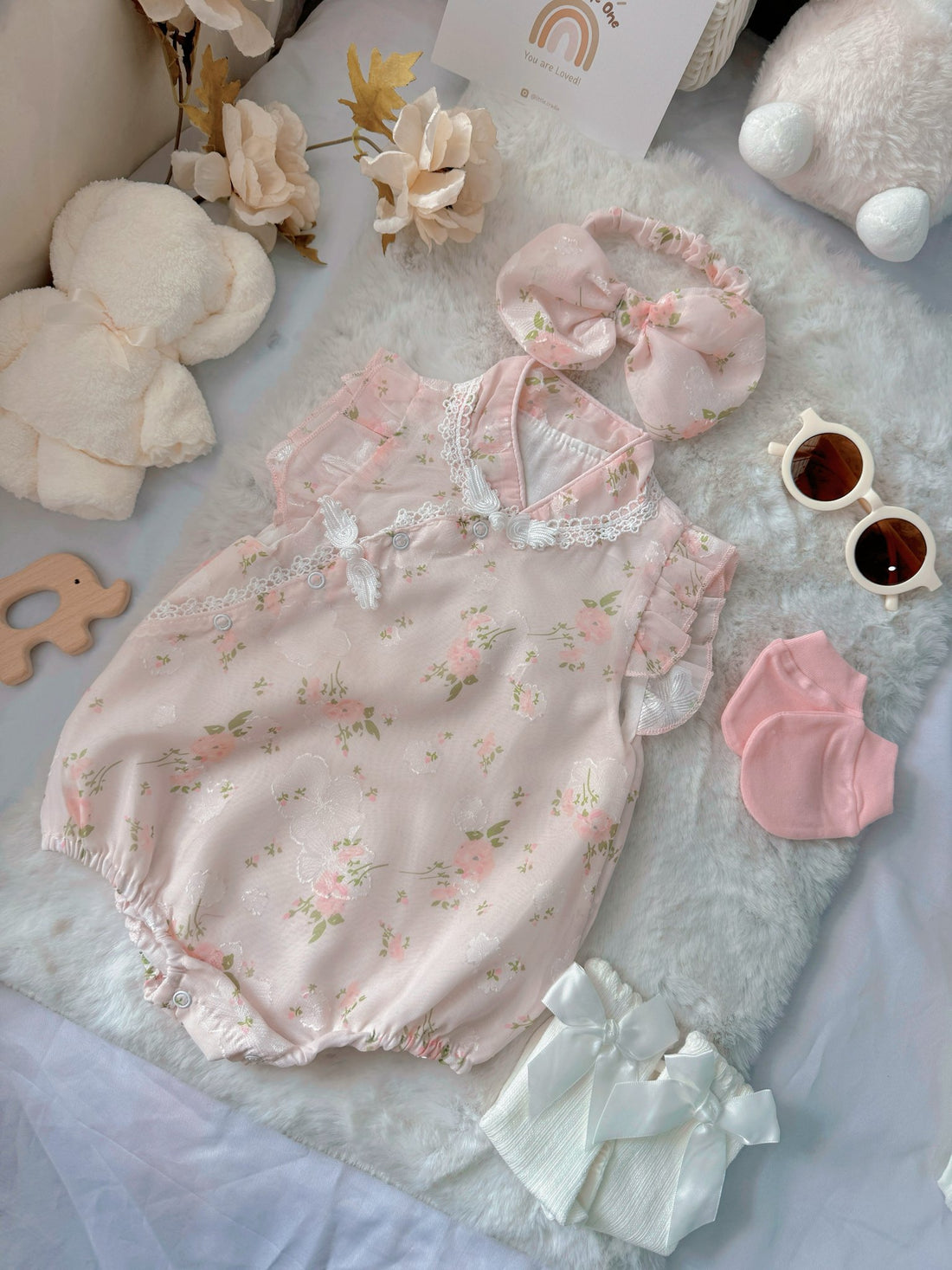 Cherry Blossom baby outfit flat lay – pink floral cheongsam-style romper with bow headband