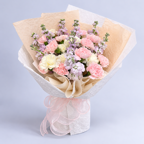 Pastel Symphony Bouquet — pink and cream carnations with lilac flowers, complete bouquet on a clean neutral background