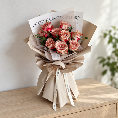 Adore Cappuccino Rose Bouquet with cappuccino roses and cream ribbon in a softly lit neutral interior.