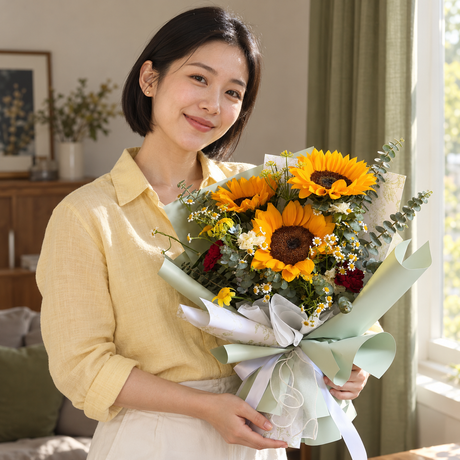 Lumi Sunflower Bouquet held by the recipient.