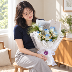 River Bleu Blue Rose Bouquet held by the same recipient in a seated candid pose.