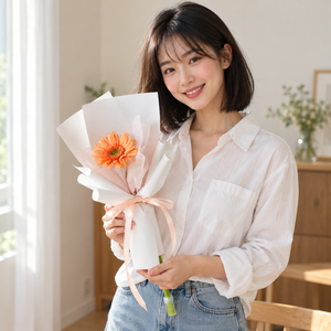Single Gerbera Bloom held by the recipient.
