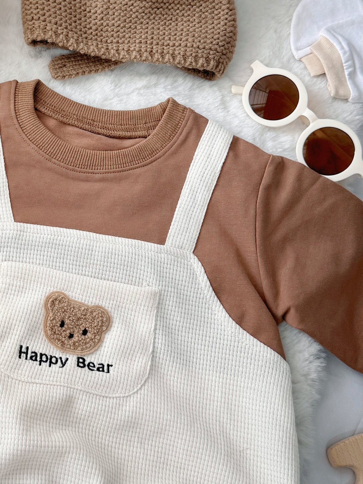 Happy Bear baby outfit flat lay – bear overall romper with bear-ear knit hat