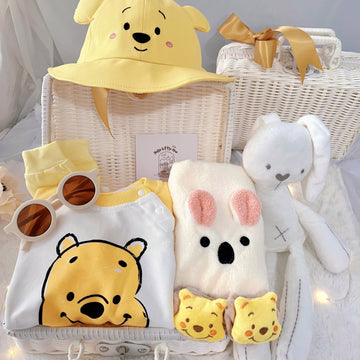 Honey Bunch premium baby gift set in a rattan basket with yellow honey-bear romper with hat and socks