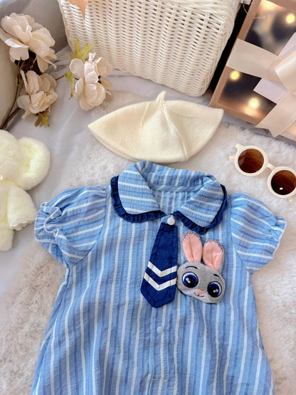 Judy Bunny baby outfit flat lay – blue striped romper with tie and bunny badge