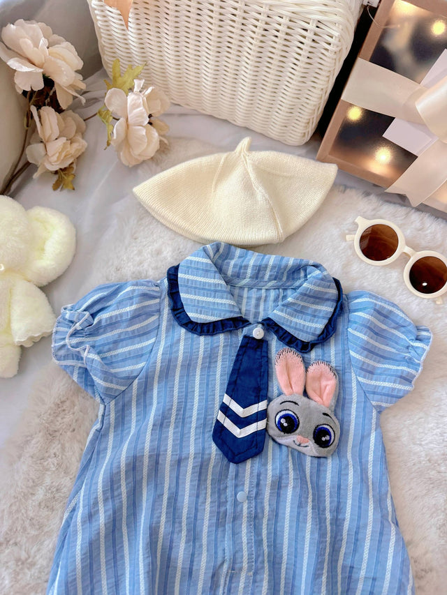 Judy Bunny baby outfit flat lay – blue striped romper with tie and bunny badge