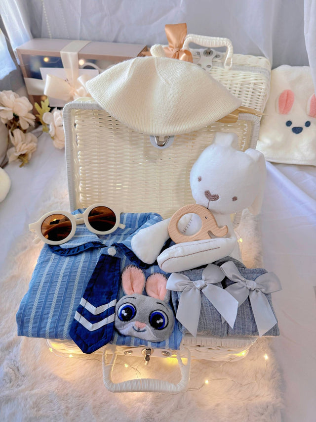 Judy Bunny premium baby gift set in a rattan basket with blue striped romper with tie and bunny badge