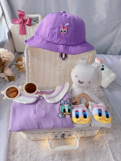 Little Daisy premium baby gift set in a rattan basket with lilac duck-collar romper with bucket hat