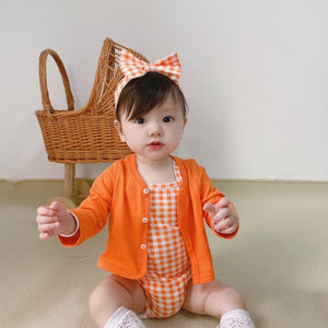 Baby wearing the Orange Buttercup orange romper and cardigan