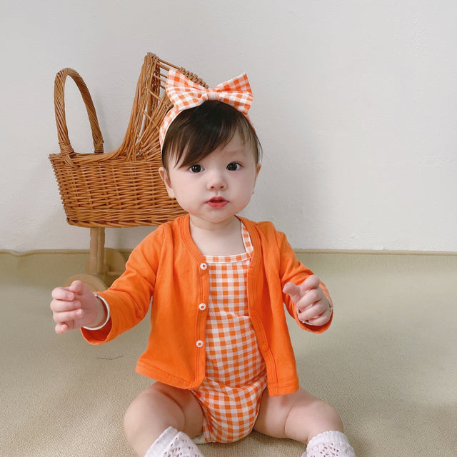 Baby wearing the Orange Buttercup orange romper and cardigan