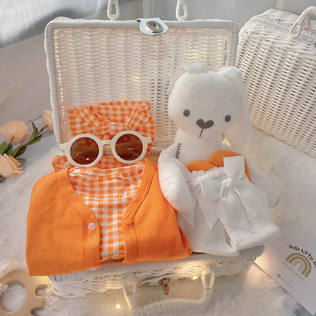 Orange Buttercup premium baby gift set in a rattan basket with orange romper and cardigan