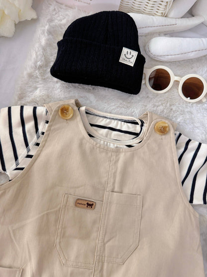 Tiny Trendsetter baby outfit flat lay – khaki overalls with striped top and black beanie
