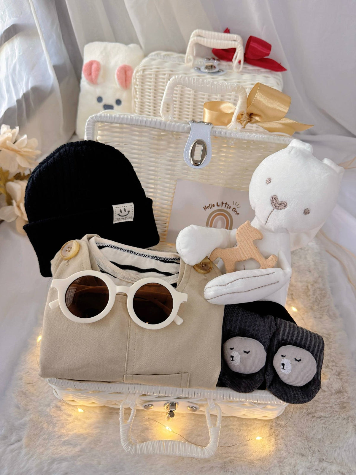 Tiny Trendsetter premium baby gift set in a rattan basket with khaki overalls with striped top and black beanie